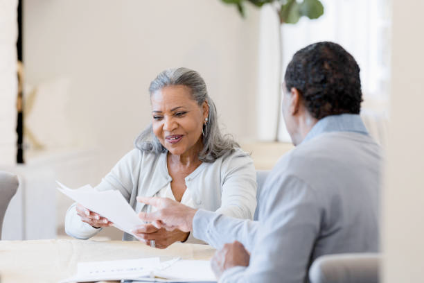 A smiling insurance agent and elderly couple discussing final expense plan documents